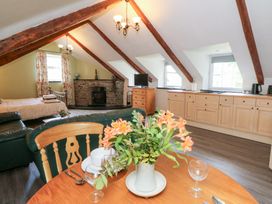 A living room with a table and flowers at Loft apartment in Llandysul