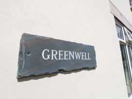 A slate sign with the name Greenwell on a wall