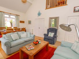 A living room with a sofa and coffee table at 1 Fernhill Avenue Weymouth