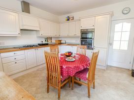 A kitchen with a dining table and appliances at 1 Fernhill Avenue Weymouth