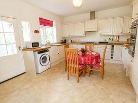 A kitchen with a table and chairs at 1 Fernhill Avenue in Weymouth