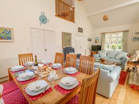 A kitchen and dining area with a table set for meal at 1 Fernhill Avenue in Weymouth