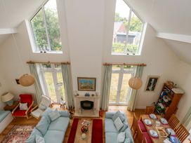 A living room with a sofa and dining area at 1 Fernhill Avenue Weymouth