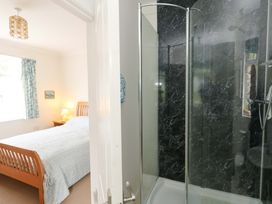 A bedroom with a bed and shower visible at 1 Fernhill Avenue Weymouth