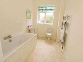 A bathroom with a bathtub, sink, and toilet at 1 Fernhill Avenue Weymouth