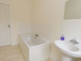 A bathroom with a bathtub and a sink at 1 Fernhill Avenue Weymouth