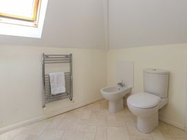 A bathroom with a toilet, bidet, towel rail, and window at 1 Fernhill Avenue in Weymouth