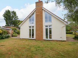 A house exterior with a chimney and large windows at 1 Fernhill Avenue in Weymouth