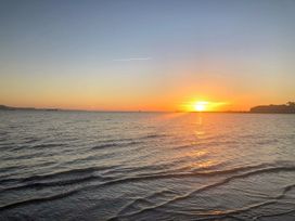 A sunset over the sea with visible waves at 1 Fernhill Avenue Weymouth