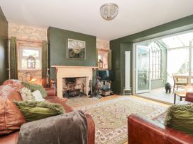 A living room with a fireplace and sofa at Yarn Cottage in Broadway