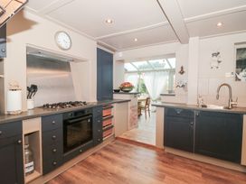A kitchen with a stove, oven, and sink at Yarn Cottage in Broadway
