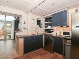 A kitchen with appliances and cabinets at Yarn Cottage in Broadway