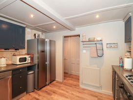 A kitchen with appliances and cabinets at Yarn Cottage in Broadway
