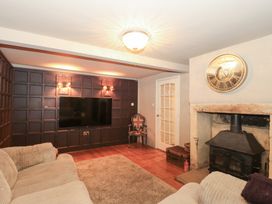 A living room with a television and fireplace at Yarn Cottage in Broadway