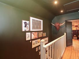 A hallway with framed artwork on the walls at Yarn Cottage in Broadway