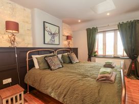 A bedroom with a bed and bedding at Yarn Cottage in Broadway