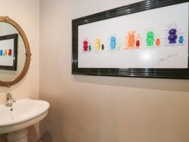 A bathroom with a mirror and a sink at Yarn Cottage in Broadway