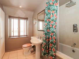 A bathroom with a sink and bathtub at Yarn Cottage in Broadway