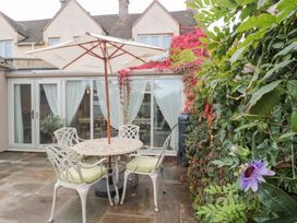 A garden with a table and chairs under an umbrella at Yarn Cottage in Broadway