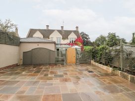 A garden with paving stones and a wooden gate at Yarn Cottage in Broadway