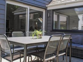 An outdoor patio area with a metal table and chairs and a plant on the table at 2 Russell Court in Salcombe