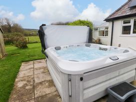 A hot tub on a patio in the garden at Belan Wen in Llanddona near Pentraeth