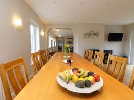 A dining room with a long table and fruit display at Belan Wen in Llanddona near Pentraeth
