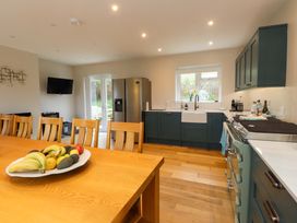 A kitchen with a table and fruit bowl at Belan Wen in Llanddona near Pentraeth