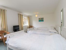A bedroom with two beds and a television at Belan Wen in Llanddona near Pentraeth