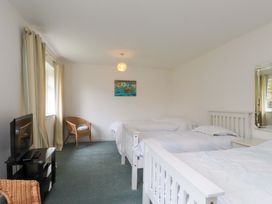 A bedroom with three beds and a television at Belan Wen in Llanddona near Pentraeth