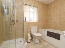 A bathroom with a shower, toilet and bathtub at Belan Wen in Llanddona near Pentraeth