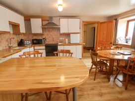 A kitchen with wooden counters and tables with chairs at Henblas Cottage in Rhyd-Y-Foel