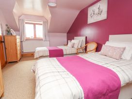 A bedroom with two single beds wooden chair chest of drawers and window at Henblas Cottage in Rhyd-Y-Foel