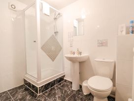 A bathroom with a shower enclosure sink toilet and a small mirror at Henblas Cottage in Rhyd-Y-Foel