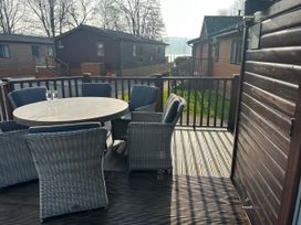 A deck with a round table and chairs at Lake View Lodge, Lakeside 3, White Cross Bay, Windermere