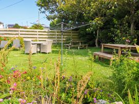 A garden with a table and chairs at Porth Ewyn in Trearddur Bay