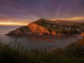 A coastal view with cliffs and houses at 8 Manleigh Park in Combe Martin