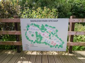 A site map for Manleigh Park attached to a wooden fence with greenery in the background