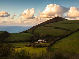 A house in a field with hills and ocean in the background at 3 Manleigh Park Combe Martin