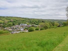 A grassy field with houses and green hills in the background at Chalet Log Cabin L12 Combe Martin