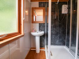 A bathroom with a pedestal sink mirror shower enclosure and a frosted window at Chalet Lodge Bunks L1 Combe Martin