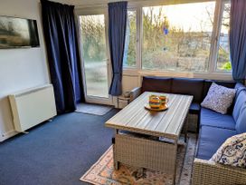 A conservatory with seating and a table at 21 The Glade in Kilkhampton