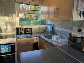 A kitchen with a sink, oven, and kettle at 21 The Glade in Kilkhampton