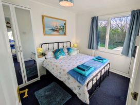 A bedroom with a bed and mirror at 21 The Glade in Kilkhampton