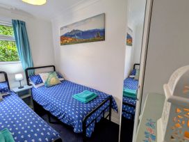 A bedroom with two beds and a bedside table at 21 The Glade in Kilkhampton