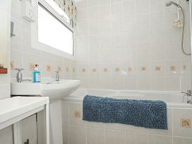 A bathroom with a bath and sink at 21 The Glade in Kilkhampton