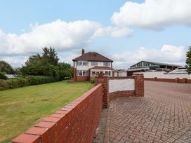 A house with a lawn and garage at Hazelgarth House in Hunmanby
