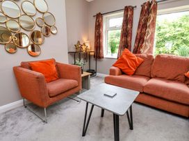 A living room with an orange sofa and armchair at Hazelgarth House in Hunmanby