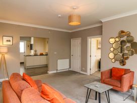 A living room with a sofa and armchair at Hazelgarth House in Hunmanby