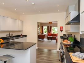 A kitchen with modern features and a view into the living room at Hazelgarth House in Hunmanby